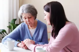 Introduction to Family Caregiving: Young Woman Comforting Sad Elderly Woman