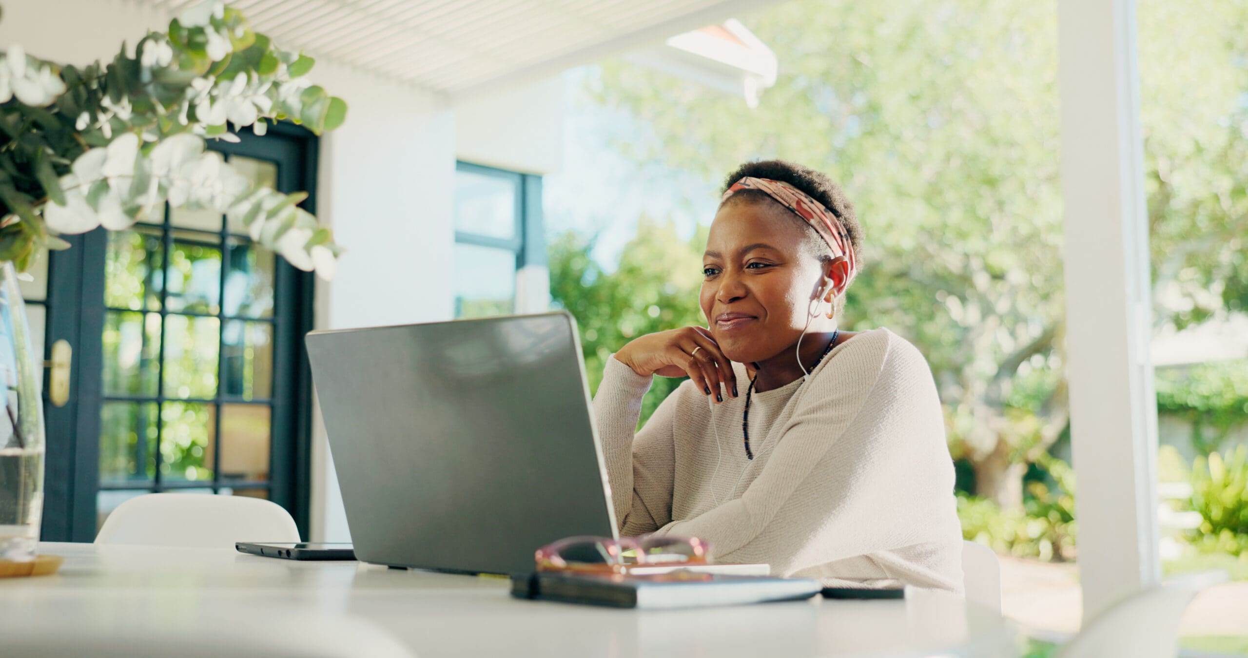 Laptop, happy and black woman with earphones for remote work, creative career and copywriting. Patio, music and person on computer for online review, writing article and digital magazine in house