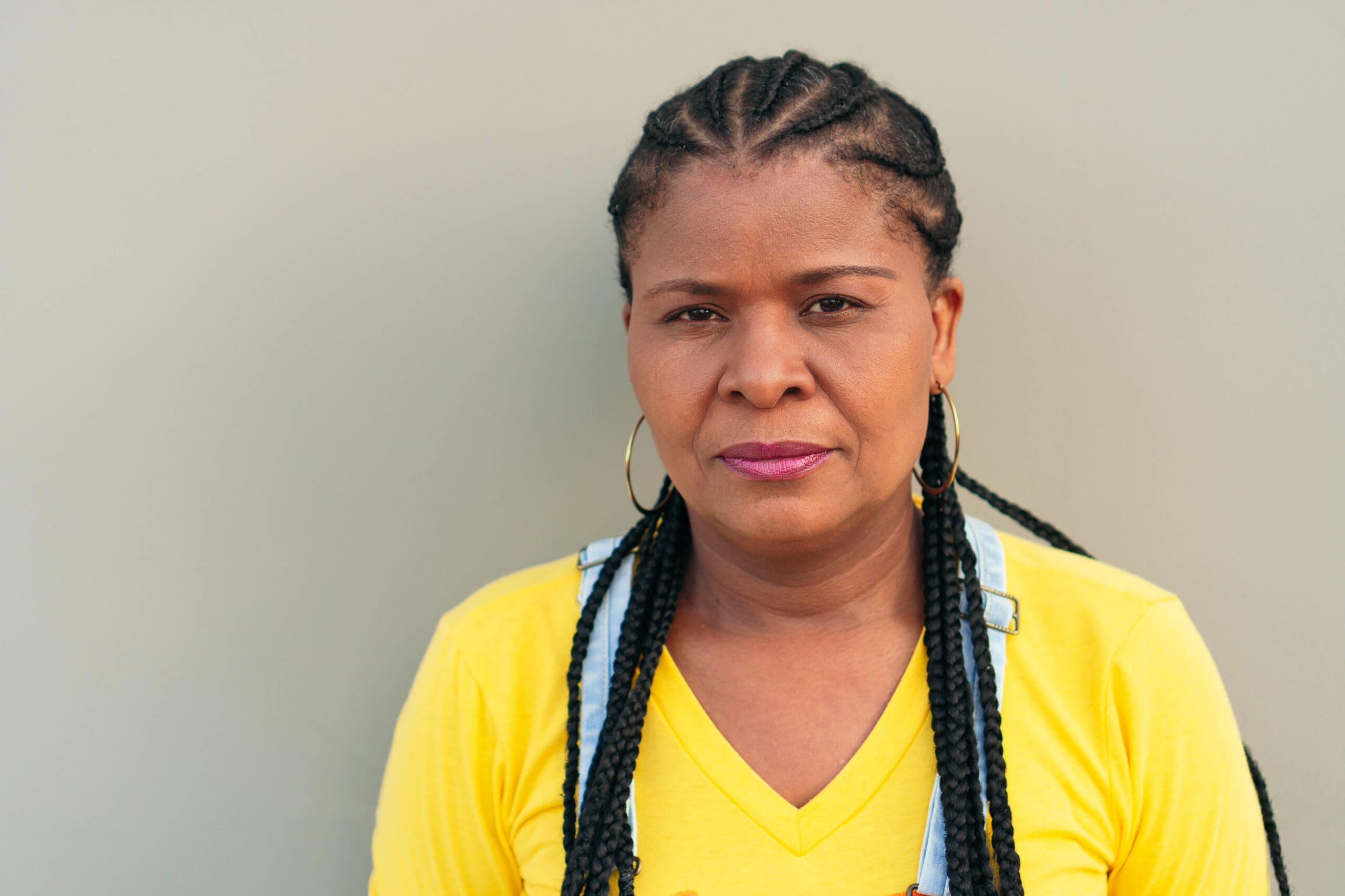 Mature black woman outside the city, looking at the camera serious. Take Control of Pain: A Veteran and Caregiver Perspective