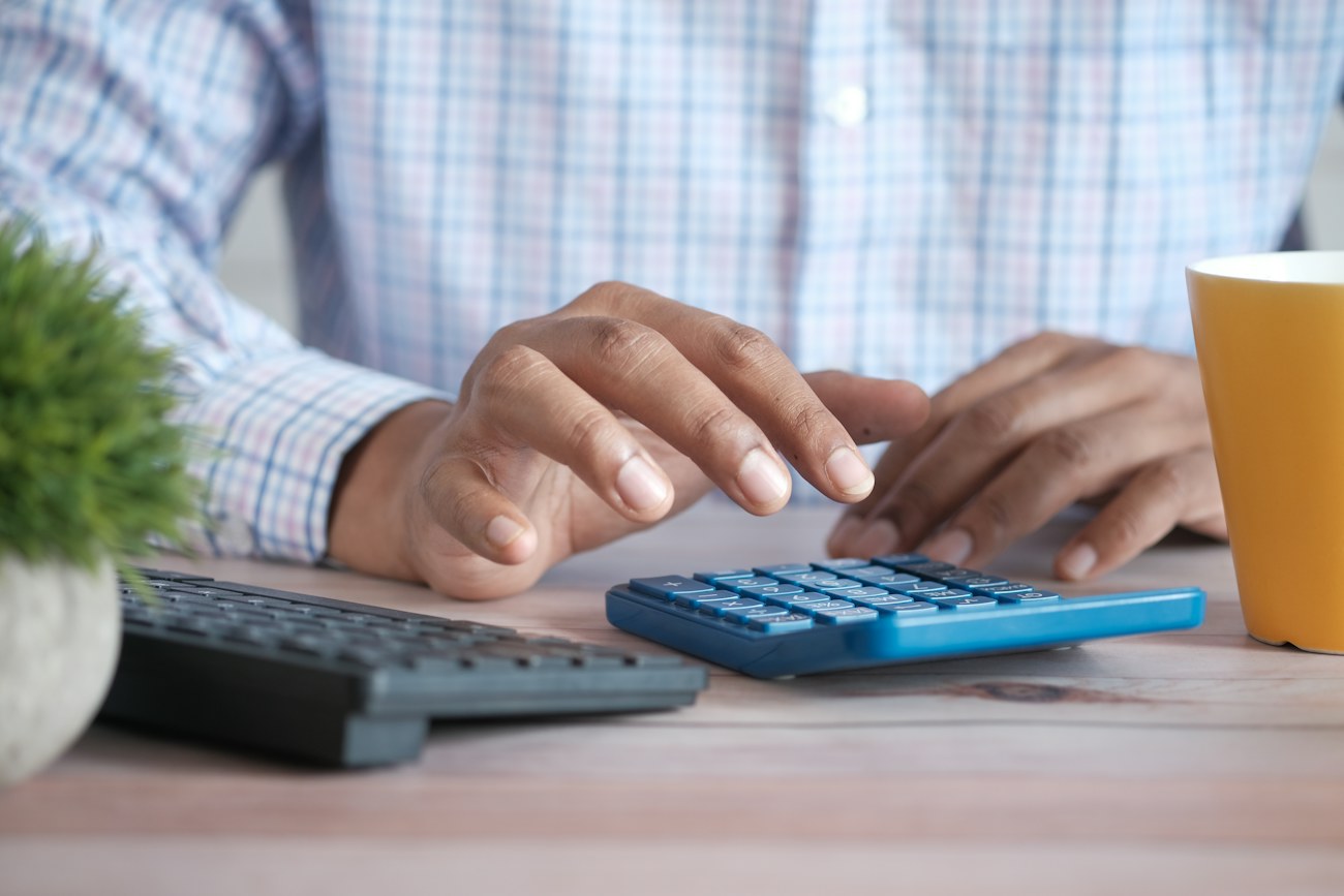 Using a calculator to review financial paperwork